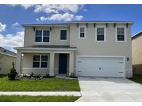 Two-story house with a white garage door and blue front door at 4807 Khloe Ct, Winter Haven, FL 33884