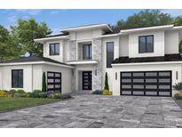 Two-story home with white siding, black garage doors, and a stone accent wall at 9144 Sheen Sound, Orlando, FL 32836