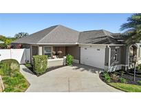 One-story home with attached garage, inviting entryway, and well-maintained landscaping at 719 Richfield St, The Villages, FL 32163