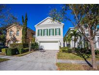 Beautiful two-story home with a white garage door and lush landscaping at 7513 Excitement Dr, Reunion, FL 34747