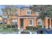 Attractive two-story townhome with dark brown front door and landscaping at 7606 Acklins Rd, Kissimmee, FL 34747