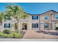 Inviting two-story townhome with brick walkway and landscaping at 8891 Geneve Ct, Kissimmee, FL 34747