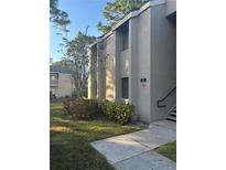 Exterior view of condo building, showing landscaping and building number 107 at 107 Springwood Cir # A, Longwood, FL 32750
