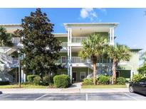 Two-story building with green exterior, balconies, and palm trees at 210 Watling Way # 24-210, Davenport, FL 33897