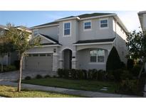 Two-story house with gray siding, a three-car garage, and landscaping at 289 Auburn Ave, Kissimmee, FL 34747