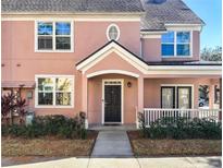 Two-story light pink house with dark brown front door and white railing at 3383 Westchester Square Blvd # 202, Orlando, FL 32835