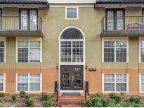 Condo building exterior featuring a well-maintained facade and attractive landscaping at 3936 Versailles Dr # 3936B, Orlando, FL 32808