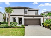 Two-story home with a modern design, two-car garage, and landscaped lawn at 4571 Cabello Loop, Kissimmee, FL 34746