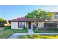 Inviting exterior of a condo with a tiled roof, landscaping, and a walkway at 547 Hunter Cir # 547, Kissimmee, FL 34758
