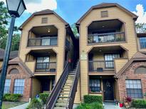 Two-story building with brick and wood siding, featuring a staircase and balconies at 485 Forestway Cir # 202, Altamonte Springs, FL 32701