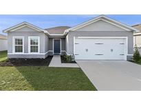 Gray house with white garage door and dark blue front door at 1224 Golden Eagle Ln, Winter Haven, FL 33880