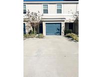 Two-story townhome with a teal garage door and landscaping at 2906 Fieldwood Cir, St Cloud, FL 34772