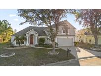 Two-story house with gray siding, red door, and attached garage at 117 Blue Heron Ct, Davenport, FL 33837