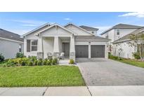 Two-story home with gray two car garage and landscaped front yard at 4473 Davos Dr, Clermont, FL 34711