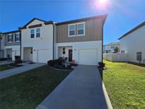Two-story townhome with two-car garage and landscaped front yard at 604 Madison Dr, Davenport, FL 33837