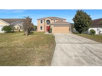 Two-story house with a red door and attached garage at 7 Bolton Ct, Kissimmee, FL 34758