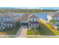 Charming two-story home with solar panels, a landscaped yard, and a waterfront view at 840 Livestock Loop, St Cloud, FL 34771