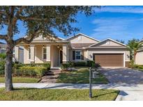 One-story home with brown garage door, landscaping, and a brick driveway at 8918 Kittanning Ave, Orlando, FL 32836