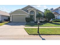 Two-story house with a green exterior, two-car garage, and a well-maintained lawn at 422 Troon Cir, Davenport, FL 33897
