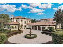 Luxury home with circular driveway, fountain, and three-car garage at 9301 Tibet Pointe Cir, Windermere, FL 34786