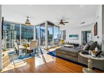 Bright living room with hardwood floors, city views, and comfortable seating at 155 S Court Ave # 1602, Orlando, FL 32801