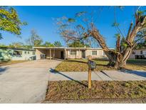 Tan single story home with carport and mature landscaping at 1921 Rockwell Rd, Orlando, FL 32808