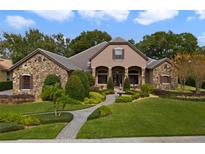 Elegant home with stone accents, lush landscaping, and a welcoming fountain at 25510 High Hampton Cir, Sorrento, FL 32776