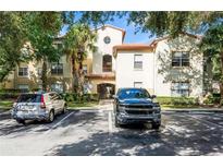 Two-story condo building with Spanish-style architecture, lush landscaping, and parking at 831 Camargo Way # 203, Altamonte Springs, FL 32714