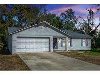 Gray house with white garage door and blue shutters, at dusk at 1073 Humphrey Blvd, Deltona, FL 32738