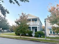 Two-story house with gray siding, balcony, and landscaping at 12285 Joshua Tree Trl, Windermere, FL 34786