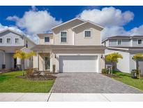 Two-story house with a white garage door and landscaping at 1230 Aloha Blvd, Davenport, FL 33897