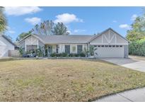 One-story home with gray exterior, landscaped lawn, and attached garage at 1010 Chance Cv, Oviedo, FL 32765