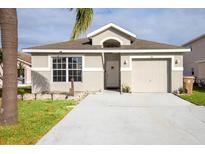 Charming single-story home with a welcoming front yard and attached garage at 111 Windy Dune Ct, Kissimmee, FL 34743