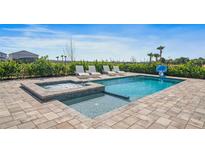 Inviting backyard oasis with a refreshing pool, spa, and lounge chairs at 159 Golden Noble St, Kissimmee, FL 34747