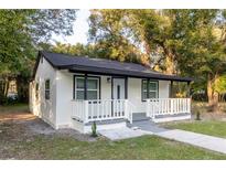 Newly renovated home with white exterior, black accents, and a small porch at 3149 W Washington St, Orlando, FL 32805
