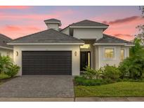 Stunning curb appeal with a modern design, two-car garage, and landscaped front yard at 104 Hampton Loop, Davenport, FL 33837