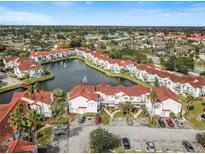 Scenic aerial view of a community with a pond and fountains at 2504 Woodgate Blvd # 107, Orlando, FL 32822