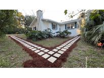 Attractive walkway leads to charming white house with blue trim at 26221 Se 159Th Ln, Umatilla, FL 32784