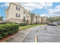 Tan three-story building with balconies and landscaped grounds at 3725 Conroy Rd # 2131, Orlando, FL 32839