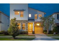 Two-story modern home with stone accents and a two-car garage at 8933 Amelia Downs Trl, Kissimmee, FL 34747