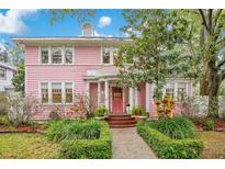 Charming pink house with white trim, manicured landscaping, and a welcoming front porch at 1217 Magnolia Ave, Sanford, FL 32771