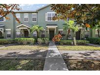 Green two-story townhome with landscaping and walkway at 159 Deepcove Rd, Winter Garden, FL 34787