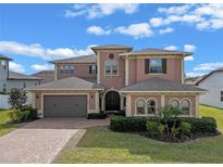 Beautiful two-story home with a paver driveway and landscaped yard at 2731 Flintlock Ave, Clermont, FL 34711