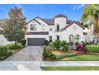 Two-story house with a tile roof, paver driveway and landscaping at 6326 Swanson St, Windermere, FL 34786