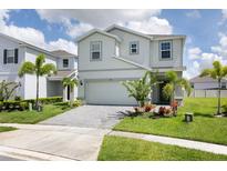 Inviting two-story home with a paved driveway, landscaped yard, and palm trees at 1671 Kona Ln, Davenport, FL 33897
