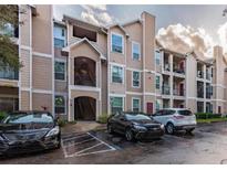 Condo building exterior with parking lot and landscaping at 2015 Erving Cir # 108, Ocoee, FL 34761
