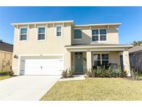 Inviting two-story home with a covered porch, landscaped yard, and attached two-car garage at 328 Conway Ave, Saint Cloud, FL 34771