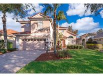 Two-story house with light peach walls, red tile roof, and palm trees at 11313 Via Andiamo, Windermere, FL 34786