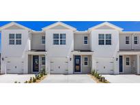 Three-unit townhome building with modern design and attached garages at 1210 Balsam Dr, Davenport, FL 33837