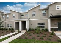 Modern two-story townhome with gray exterior and white accents at 4241 Paragraph Dr, Kissimmee, FL 34746